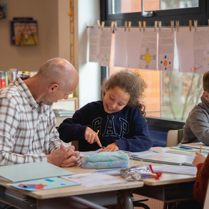 Onderwijsambassadeur Jan Joost in de klas zittend bij kinderen Onderwijsambassadeur in de klas. Jan Joost zittend bij kinderen.